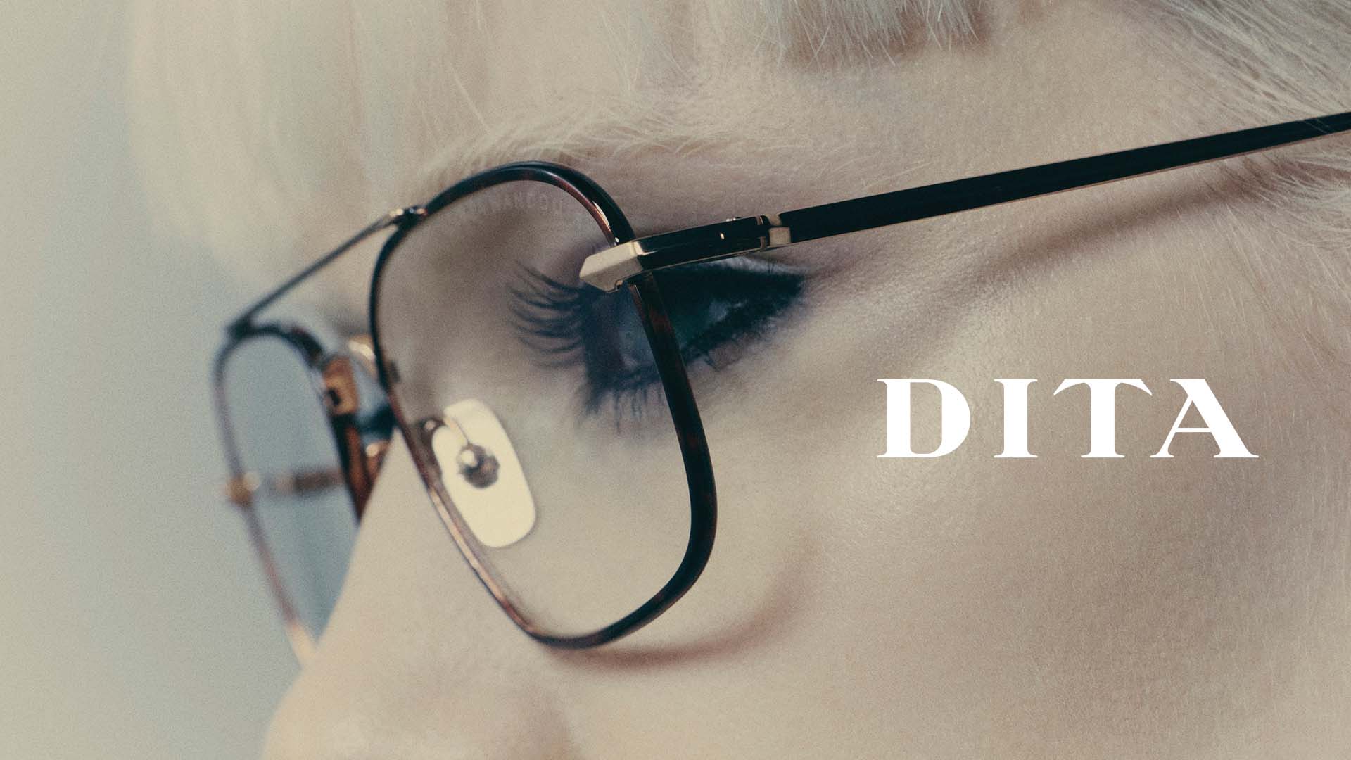 Gros plan sur lunettes DITA fines écaille‑or, portées par un modèle blond, désormais disponibles chez Winston